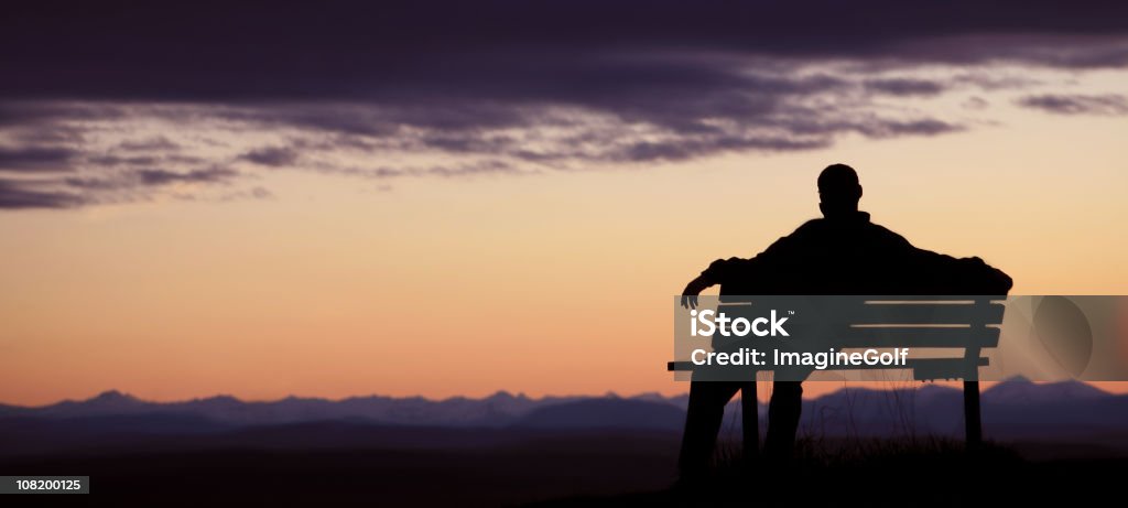 Silhouette d'un homme assis sur un banc au crépuscule - Photo de Banc public libre de droits