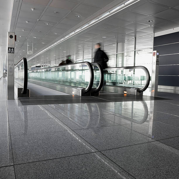 Motion Blur of People Walking on Moving Sidewalk at Airport  airport travelator stock pictures, royalty-free photos & images