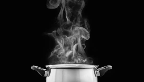 vapore su pentola di cottura in cucina su sfondo scuro - dark cooking food food and drink foto e immagini stock