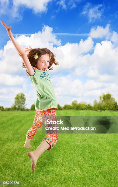 Menina Saltar Sobre Grama - Fotografias de stock e mais imagens de Ao Ar Livre - Ao Ar Livre, Berrar, Braço Humano