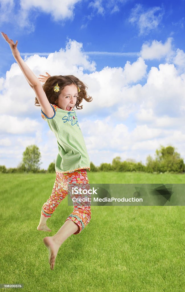 Маленькая девочка, прыжки на траве - Стоковые фото Беззаботный роялти-фри