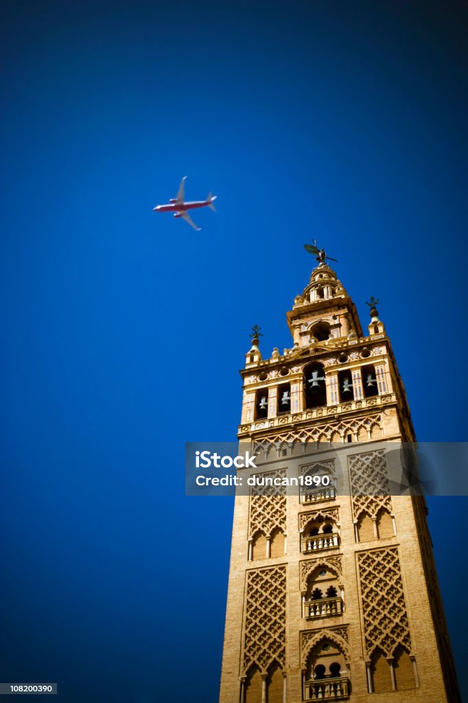 La Giralda catedral Bell Tower con avión en el cielo - Foto de stock de Avión libre de derechos