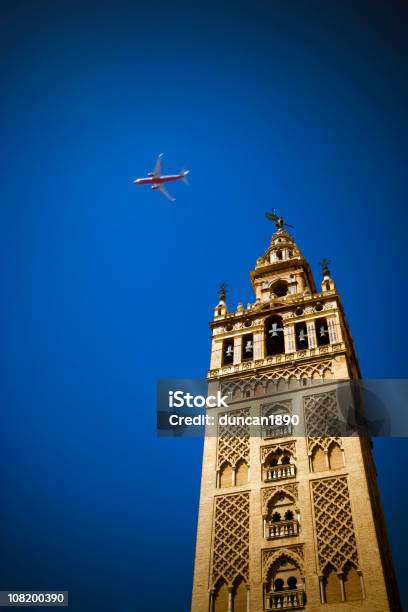 La Giralda Catedral Bell Tower Con Avión En El Cielo Foto de stock y más banco de imágenes de Avión