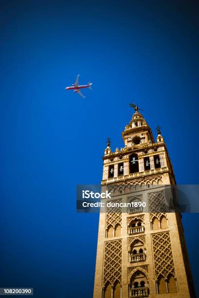 La Giralda Cattedrale Bell Tower Con Aeroplano Nel Cielo - Fotografie stock e altre immagini di Aeroplano