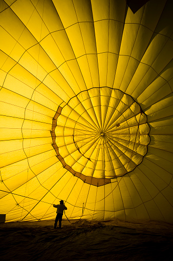 A hot air balloon pilot checks the inner workings of his balloon before a flight. 