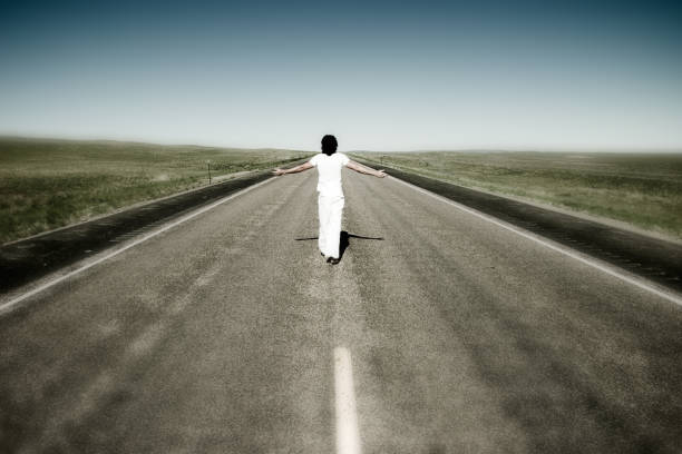 istock Person Walking Down Empty Road with Arms Outstretched 108200484