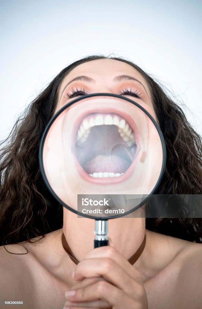 Femme tenant une loupe devant sa bouche - Photo de Adulte libre de droits