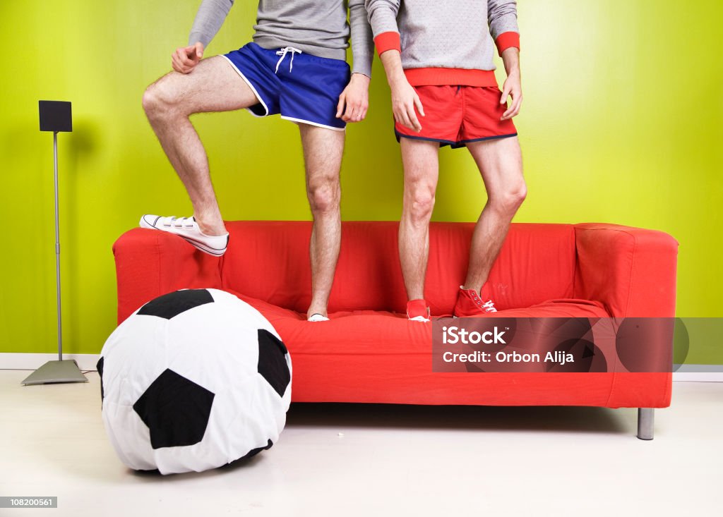 Dois homens de pé no sofá com bola de futebol de Almofada - Royalty-free Almofada - Roupa de Cama Foto de stock