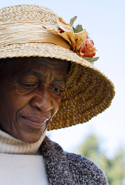 African woman smiling on camera holding a buch of bananas