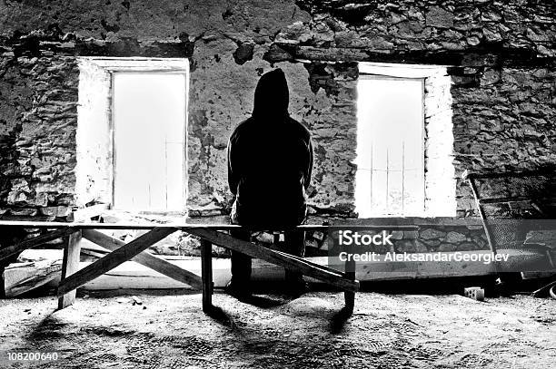 Photo libre de droit de Homme Assis Sur Un Banc Entre Deux Fenêtres Dans La Chambre banque d'images et plus d'images libres de droit de Pièce - Intérieur de maison