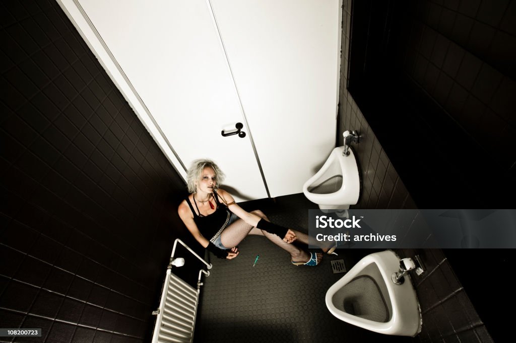 Young Woman Sitting in Restroom Injecting Drugs from Needle  Addict Stock Photo