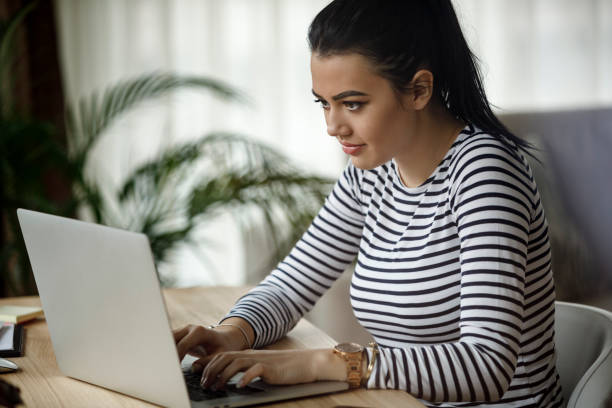 istock Young woman using laptop at home 1082011336