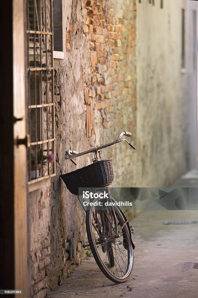 Bicicleta apoyarse en la pequeña calle en pared - Foto de stock de Apoyarse libre de derechos