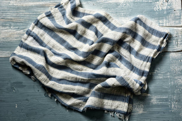 istock white and blue striped scarf on wooden table - closeup 1082014254