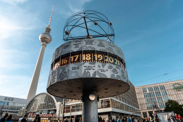 Berlin, Germany - October 8, 2018: The Urania World Clock at Alexanderplatz under blue sky. Television tower in background.