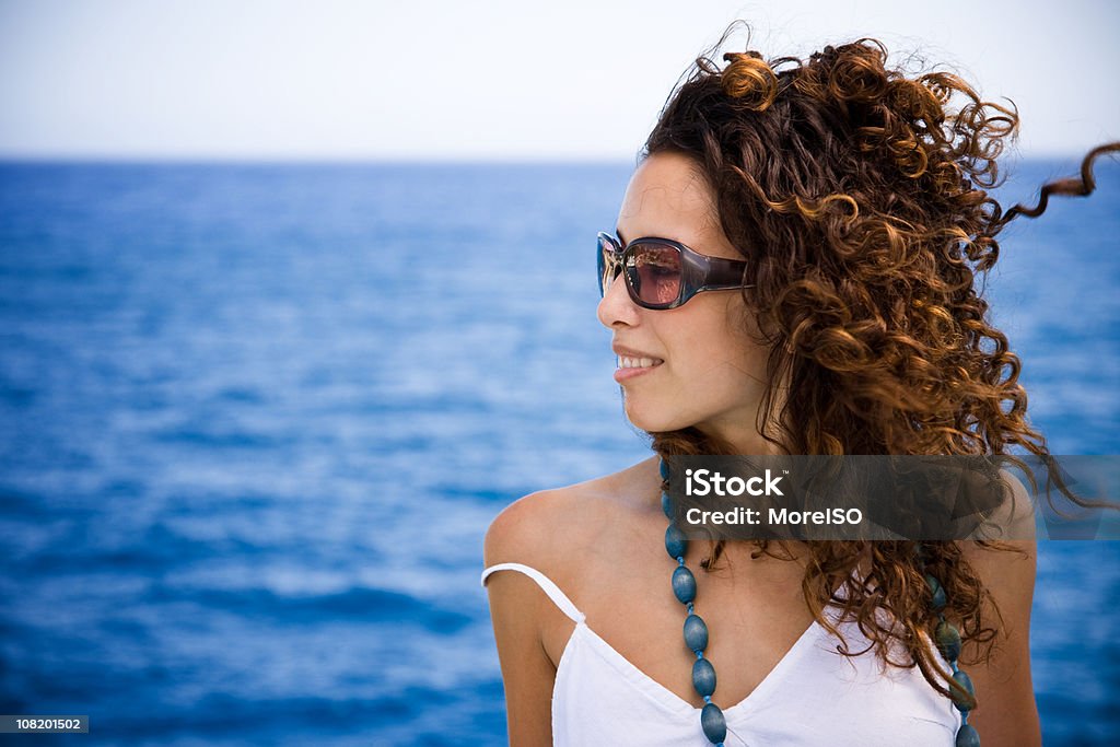 Hermosa Chica mirando lejos contra el mar de fondo azul - Foto de stock de 20 a 29 años libre de derechos