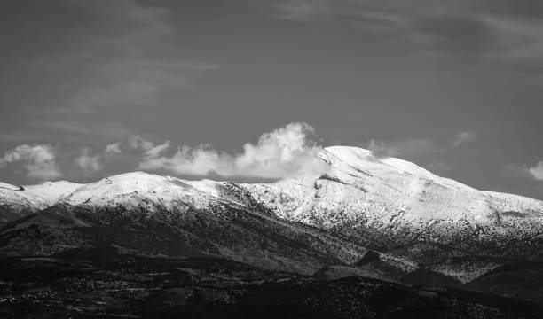 istock The view of snowy mountain peak with clouds. Black and white. 1082016128