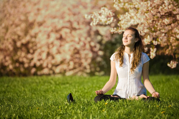 istock Young Woman Meditating in Field 108201631