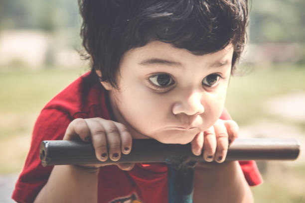 istock Sad Indian kid riding seesaw board at the playground under sunlight 1082017658