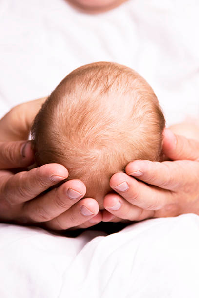 Closeup of baby head in fsther's hand.