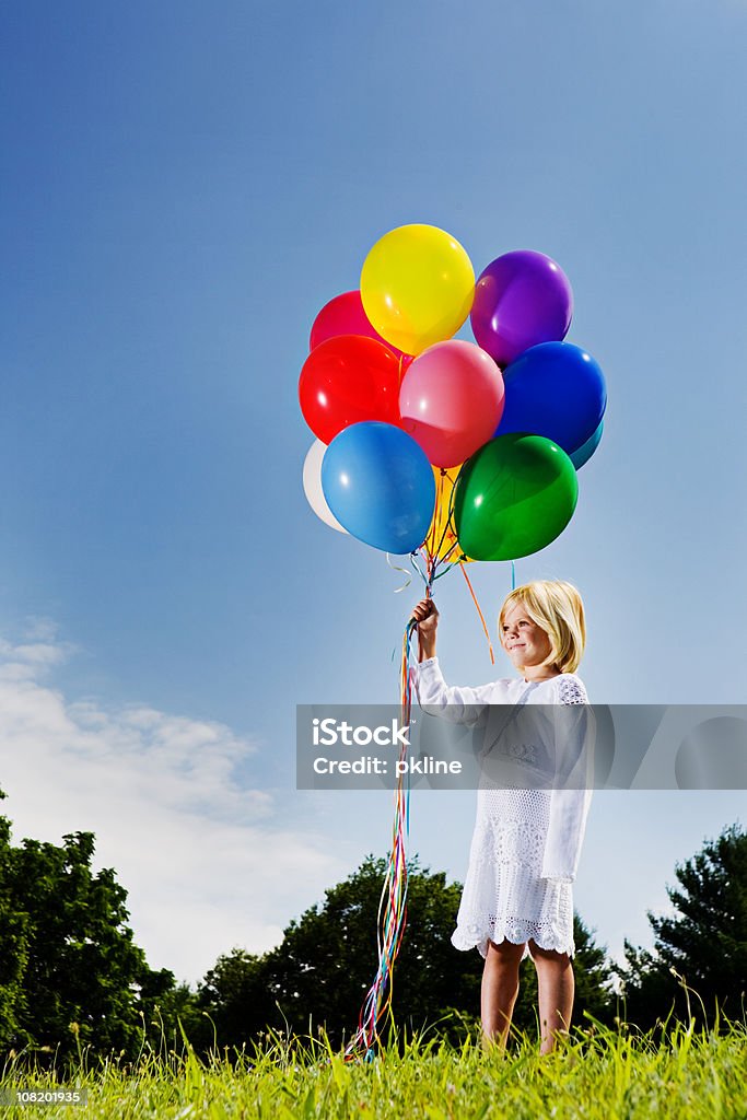 Маленькая девочка с разноцветных тепловых аэростатов Монгольфье стоит улыбающегося - Стоковые фото Воздушный шарик роялти-фри