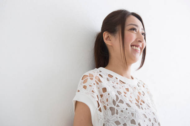 istock A woman leaning against the wall with a smile 1082020546