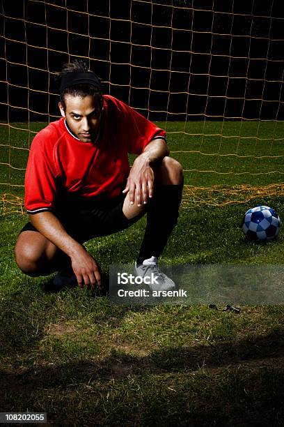 Foto de Jogador De Futebol No Chão Em Frente Da Rede À Noite e mais fotos de stock de Adulto