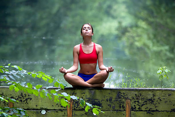 Young Woman Meditating in Forest stock photo