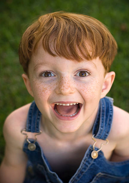 Asian baby boy playing and smiling on the grass in the garden on beautiful spring day.