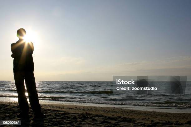 Silueta De Hombre De Pie En La Playa Foto de stock y más banco de imágenes de Adulto - Adulto, Aire libre, Anochecer