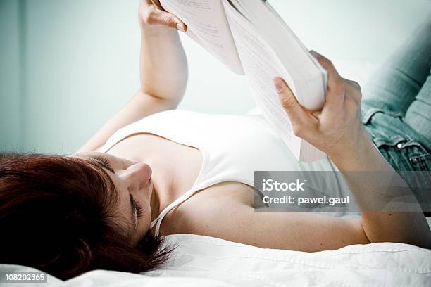 Foto de Jovem Mulher Deitada Na Cama Lendo Livro e mais fotos de stock de 25-30 Anos - 25-30 Anos, Aconchegante, Adulto