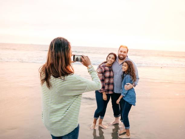 istock Family on the beach taking photos 1082024010