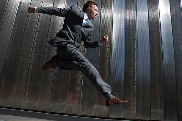 istock Serious Businessman Jumping Outdoors City Sidewalk Shiny Building 108202510