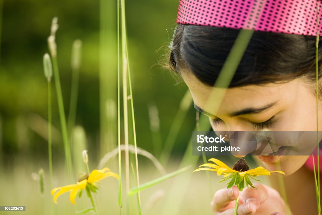 Close up of smiling teen girl smelling a Black-Eyed Susan  14-15 Years Stock Photo