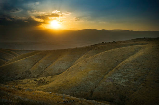 The sun rises over the mountains in a view from Israel looking toward the Jordan valley.  Horizontal with copy space.