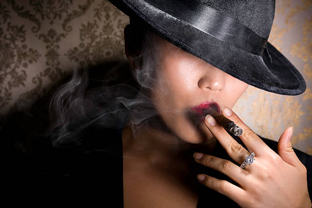 Asian Gangster Woman in Fedora Smoking Cigar with Diamond Ring stock photo