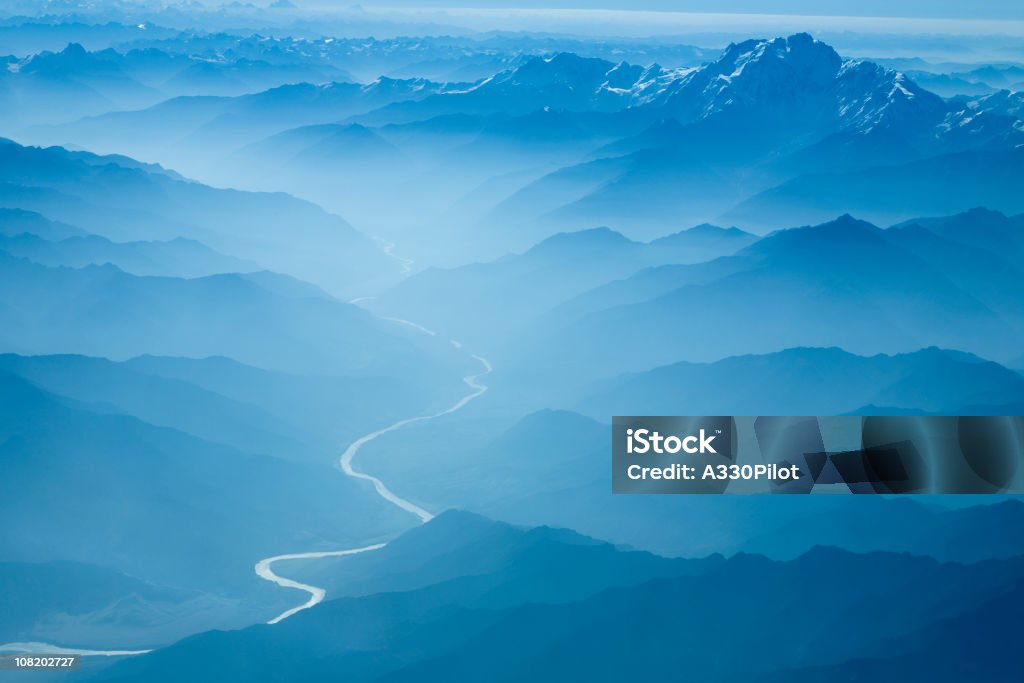 Aerial View of River Winding Through Foggy Himalyan Mountains  Aerial View Stock Photo