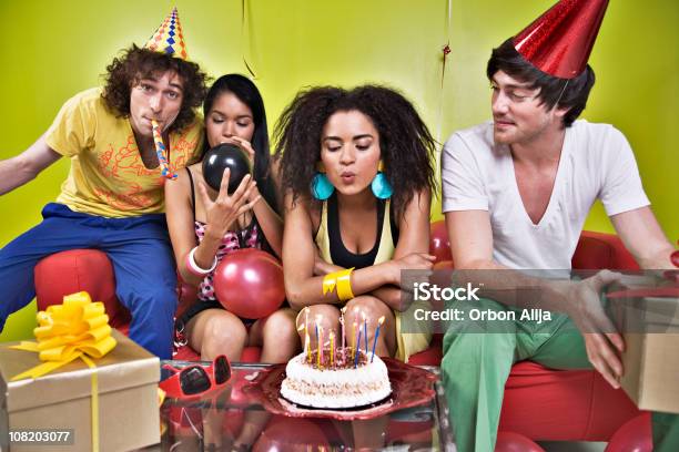 Foto de Jovem Soprando Velas Em Bolo De Aniversário Celebrar Com Os Amigos e mais fotos de stock de Adulto