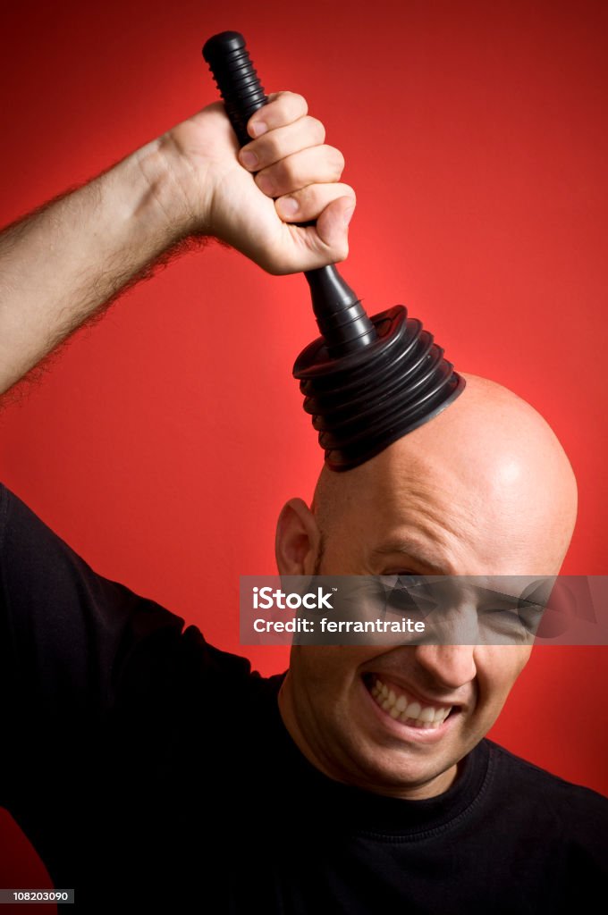 Man Trying to Pull Plunger off Head Man plunging some blocked ideas. Plunger Stock Photo