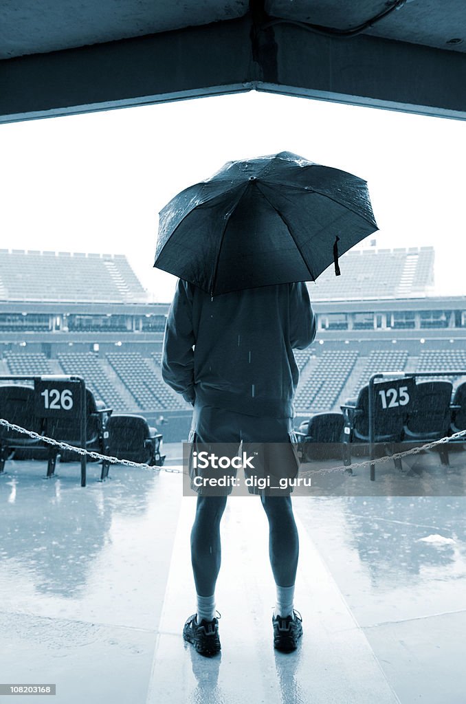 Homem segurando Guarda-chuva em pé na entrada de Sports Stadium - Royalty-free Guarda-chuva Foto de stock
