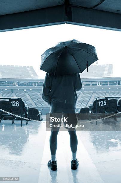 Homem Segurando Guardachuva Em Pé Na Entrada De Sports Stadium - Fotografias de stock e mais imagens de Guarda-chuva