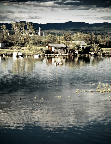 Panorama of Deliblato village and lake kraljevac with the church of saint nicholas (crkva svetog nikole). Deliblato is a village in Serbia , situated in the Kovin municipality in the Vojvodina province. The village has a total population of 3,498 (2002 census), with a Serb ethnic majority and a Romanian minority. The Deliblatska Peara (Deliblato Sands), the largest sandy area in Europe, was named after this village.This image showcases the serene landscape of Deliblato and its lake in Serbia. The clear blue sky and tranquil waters create a picturesque and calming scene. Surrounded by natural vegetation and a horizon dotted with trees, Deliblato offers a peaceful escape into nature. This destination is perfect for travelers seeking tranquility and scenic beauty, making it an idyllic spot for photography and relaxation.The Church of Saint Nicholas (Crkva Svetog Nikole) in Deliblato, Serbia, stands proudly before the serene waters of Lake Kraljevac. This Orthodox church is a cultural and spiritual landmark in the rural village of Deliblato, representing both religious heritage and the natural beauty of the Serbian countryside. Surrounded by nature and peaceful landscapes, the church serves as a destination for both religious pilgrims and tourists. Its traditional architecture and serene setting offer a glimpse into Serbia's rural charm.