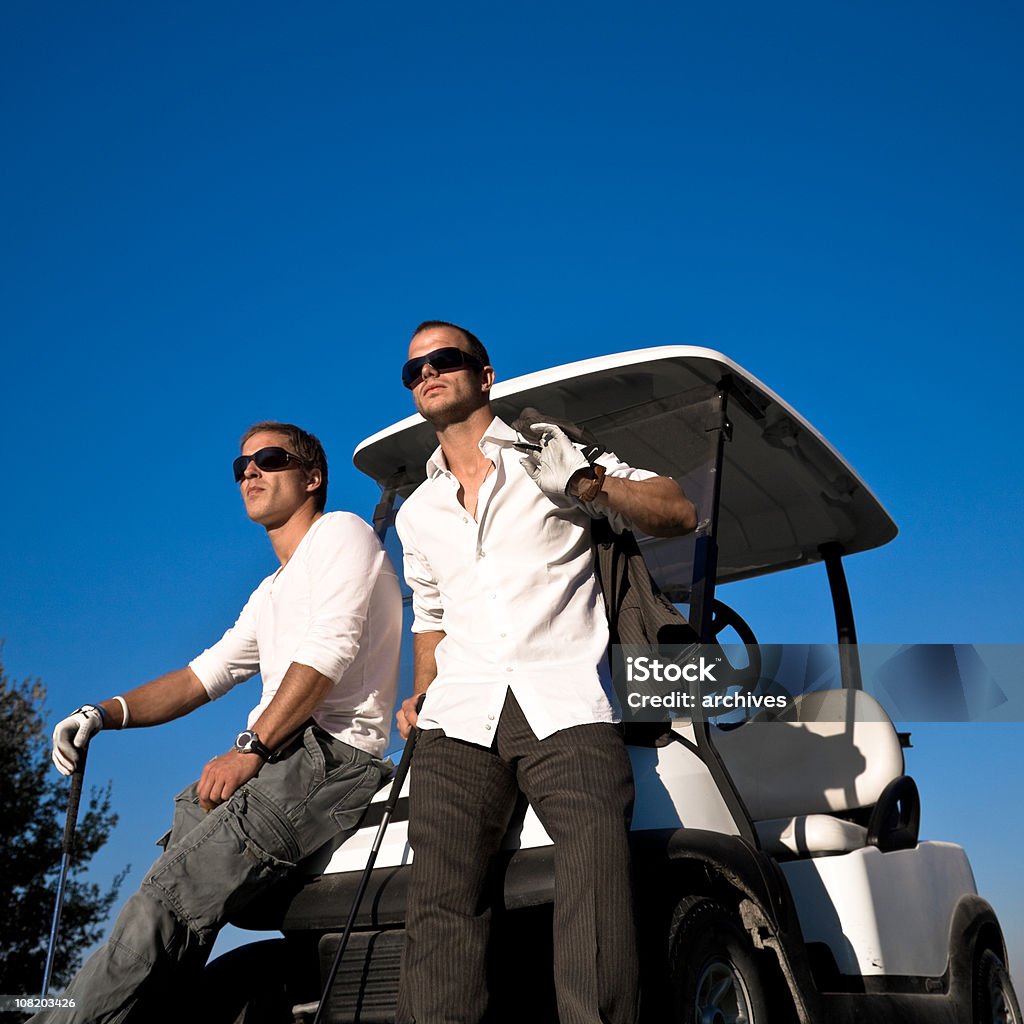 2 つの若い男性ゴルファーのリラックスにはゴルフカート - 2人のロイヤリティフリーストックフォト