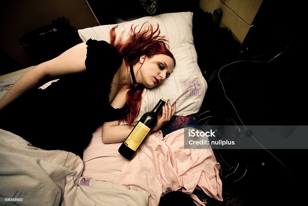 Jovem mulher deitada na cama com uma garrafa de vinho - Foto de stock de Cama royalty-free