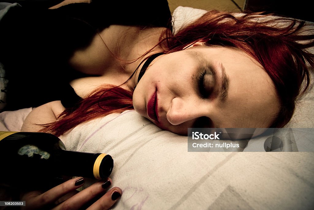 젊은 여자 라잉 침대 (와인 한 병 포함 - 로열티 프리 잠자기 스톡 사진