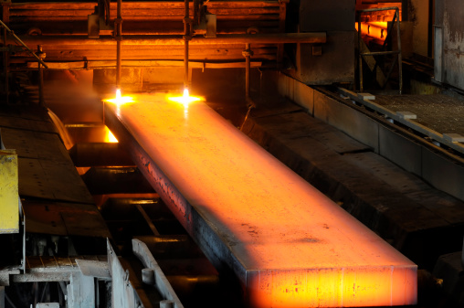 Molten steel pouring into a cast in a steel mill.