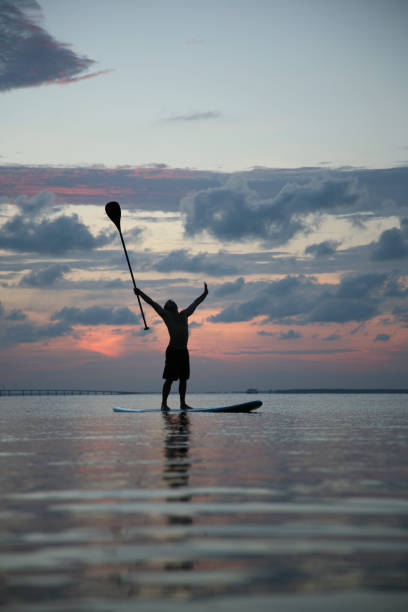 zwycięstwo na morze nowe sports trend paddle na pokład samolotu zachód słońca - surfing sport extreme sports success zdjęcia i obrazy z banku zdjęć