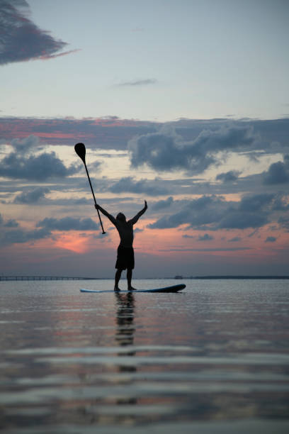 vitória no mar novo sports tendência paddle ao pôr-do-sol - surfing sport extreme sports success - fotografias e filmes do acervo