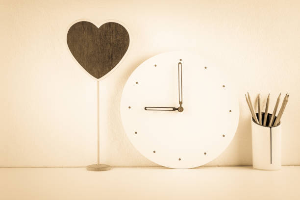 istock Contemporary office desk or workplace concept : Business / personal working space, office supply on table e.g blank / empty heart shaped chalkboard, analog wall clock, clear & clean theme, sepia toned 1082036190
