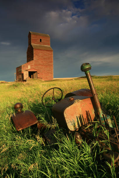 旧トラクターと穀物エレベーターオンファーム - canada saskatchewan grain elevator prairie ストックフォトと画像